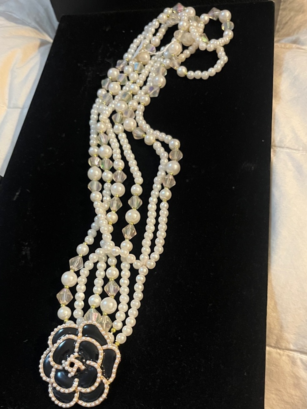 Elegant Multi-Strand Pearl Necklace with Black Flower Accent